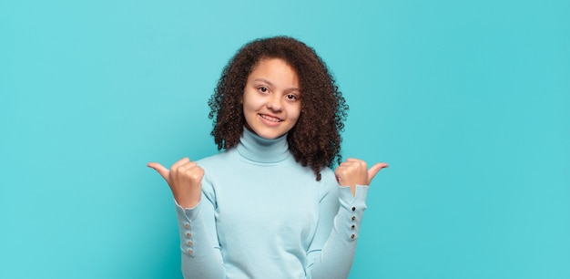 Giovane donna graziosa che gesturing sulla parete colorata