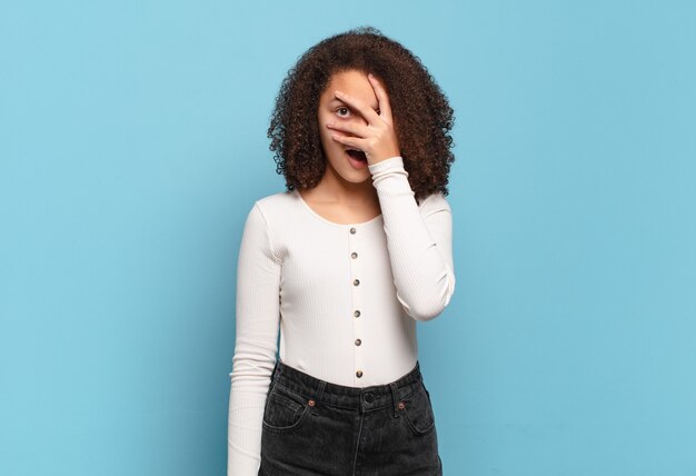 Giovane donna graziosa che gesturing sulla parete colorata