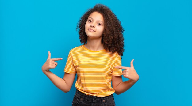 Giovane donna graziosa che gesturing sulla parete colorata