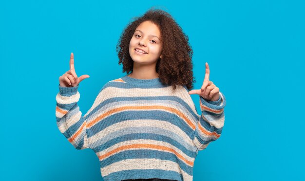 Giovane donna graziosa che gesturing sulla parete colorata