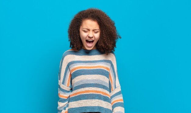 Giovane donna graziosa che gesturing sulla parete colorata