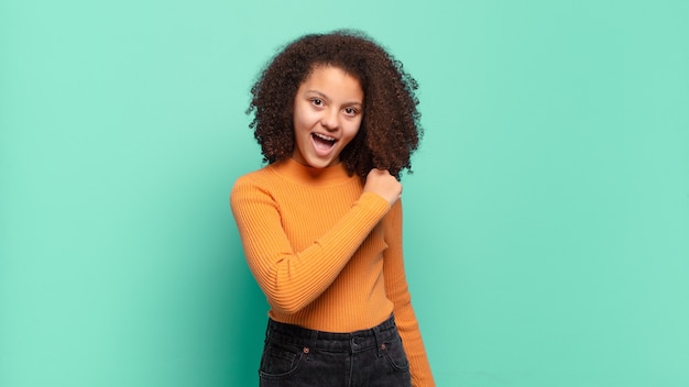 Giovane donna graziosa che gesturing sulla parete colorata