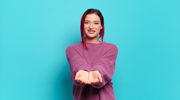 Giovane donna graziosa che gesturing sulla parete colorata