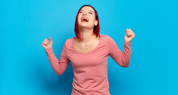 Giovane donna graziosa che gesturing sulla parete colorata