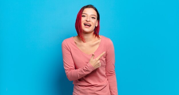 Giovane donna graziosa che gesturing sulla parete colorata