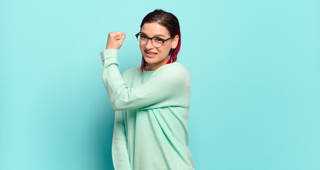 Giovane donna graziosa che gesturing sulla parete colorata