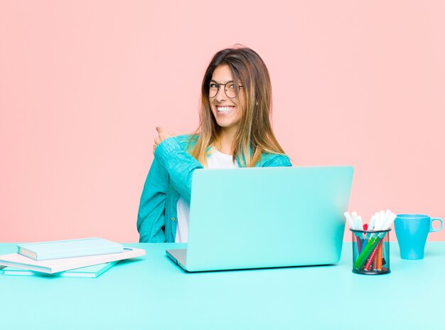 Giovane donna graziosa che lavora con un computer portatile sentirsi felice, positivo e di successo