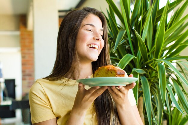 Giovane donna graziosa che mangia colazione a casa