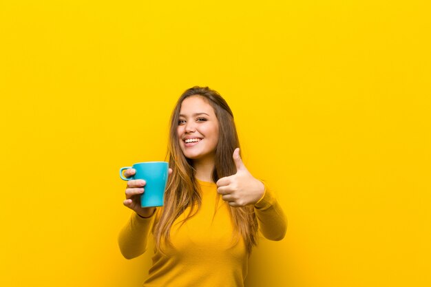 Giovane donna graziosa che mangia un caffè