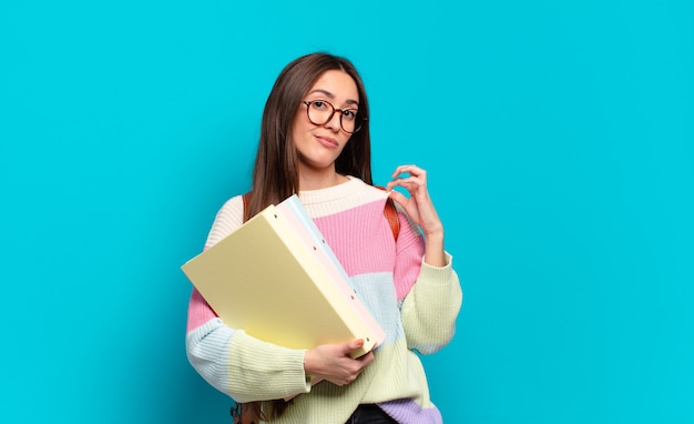 Giovane donna graziosa che sembra arrogante, di successo, positiva e orgogliosa, indicando se stessa