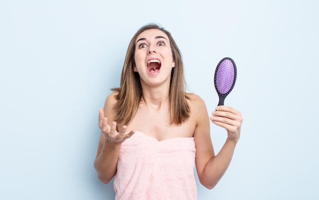 Giovane donna graziosa che sembra disperata, frustrata e stressata. concetto di spazzola per capelli