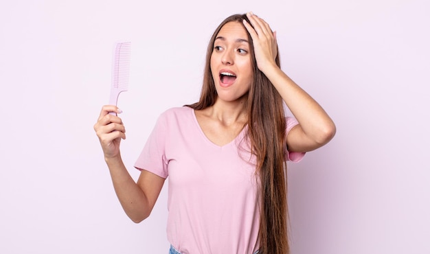 Giovane donna graziosa che si sente felice, eccitata e sorpresa. concetto di pettine per capelli