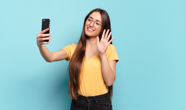 Giovane donna graziosa che utilizza il suo cellulare.