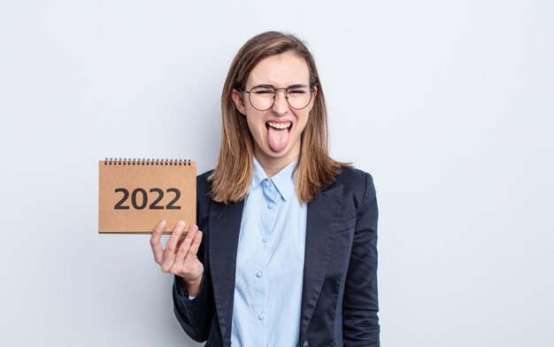 Giovane donna graziosa con atteggiamento allegro e ribelle, scherzando e tirando fuori la lingua. concetto di calendario