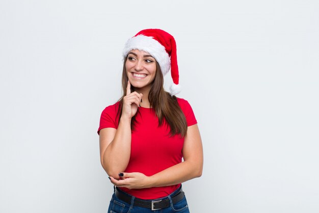 Giovane donna graziosa con cappello santa. Concetto di natale.