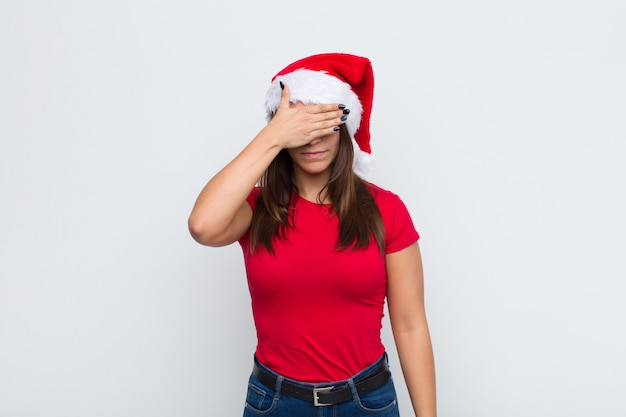 Giovane donna graziosa con cappello santa. Concetto di natale.