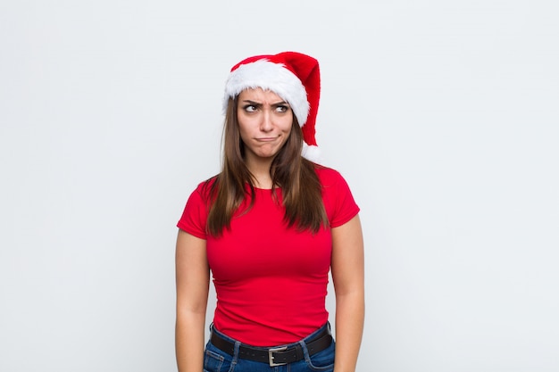 Giovane donna graziosa con cappello santa. Concetto di natale.