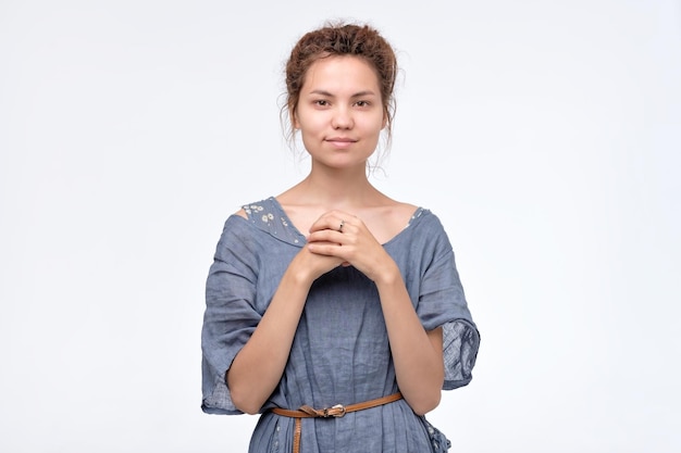 Giovane donna graziosa con i dreadlocks che sorride fiducioso che sembra felice in vestito blu