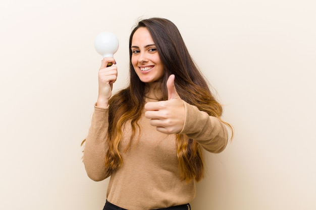 Giovane donna graziosa con lampadina, avendo un'idea