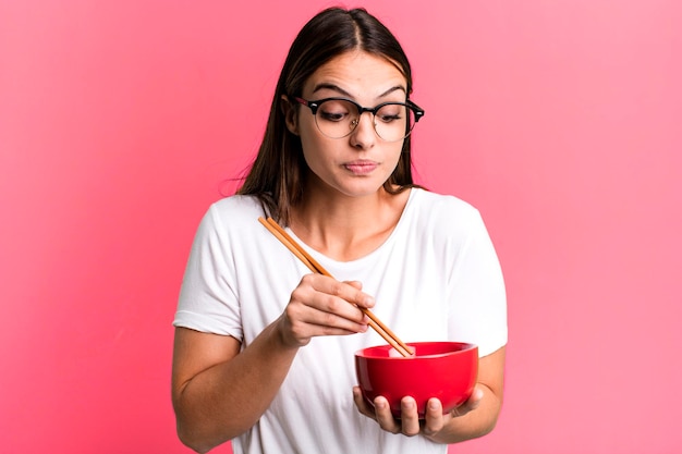 Giovane donna graziosa con un bolw di ramen di tagliatelle giapponesi