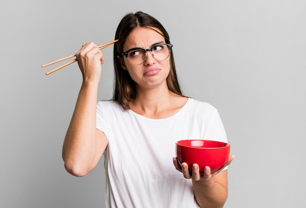 Giovane donna graziosa con un bolw di ramen di tagliatelle giapponesi