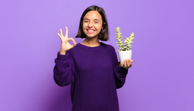 Giovane donna graziosa con un cactus