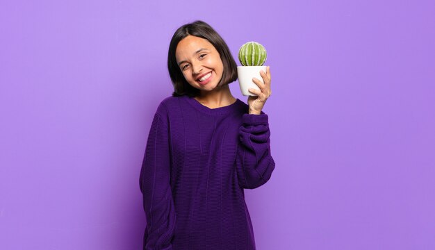 Giovane donna graziosa con un cactus