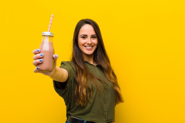 Giovane donna graziosa con un frappè al cioccolato