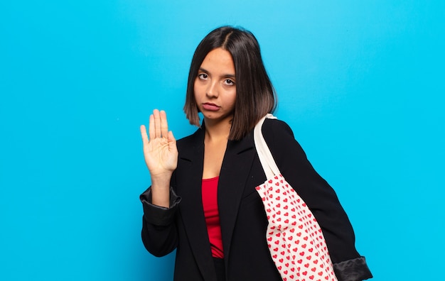 Giovane donna graziosa con una borsa di cuori