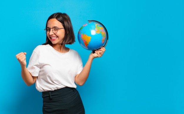 Giovane donna graziosa con una mappa del globo del mondo