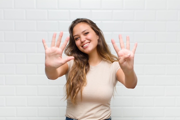 giovane donna graziosa contro il muro bianco