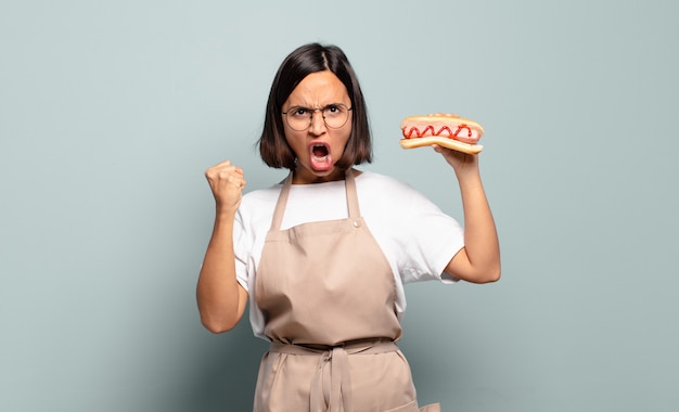 Giovane donna graziosa del cuoco unico. concetto di fast food