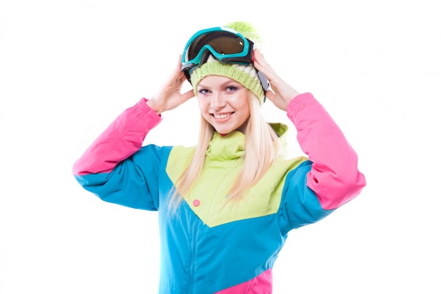 Giovane donna graziosa in attrezzatura dello sci e vetri di sci