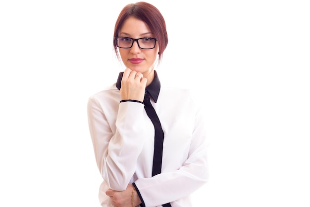 Giovane donna graziosa in camicia bianca e nera con occhiali neri su sfondo bianco in studio