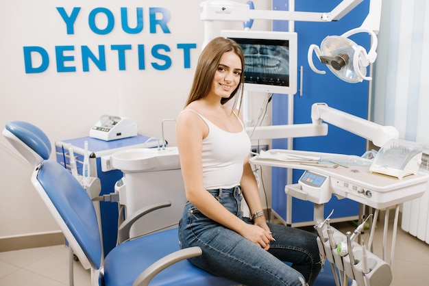 Giovane donna graziosa in poltrona del dentista in attesa di trattamento