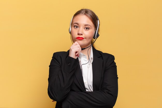 Giovane donna graziosa. pensare o dubitare del concetto di telemarketer di espressione