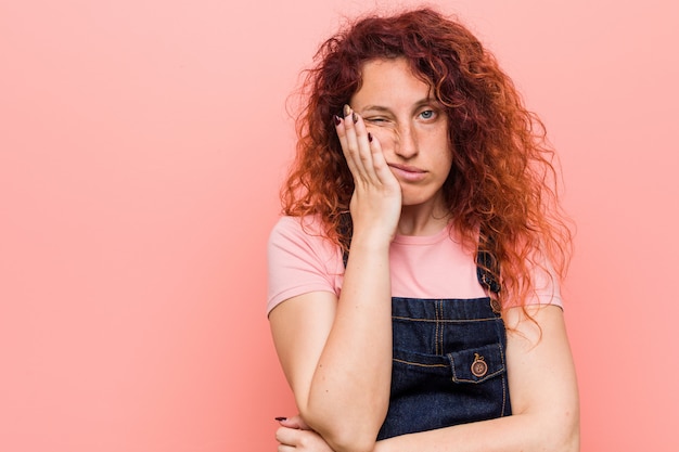 Giovane donna graziosa rossa dello zenzero annoiata