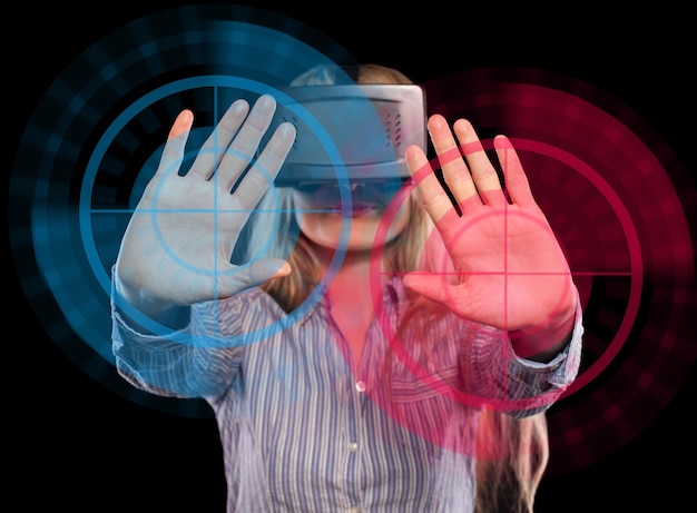Giovane donna immersa in un videogioco interattivo di realtà virtuale che fa gesti su sfondo nero.