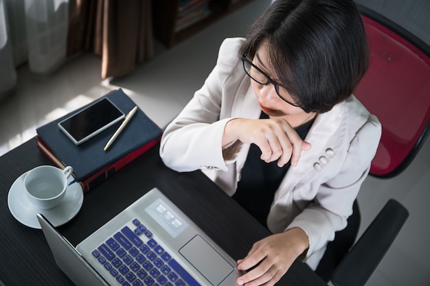 Giovane donna in abbigliamento casual intelligente che lavora al computer portatile