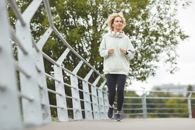 Giovane donna in abbigliamento sportivo facendo sport all'aperto nel giorno d'estate