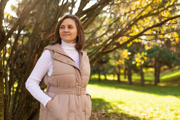 Giovane donna in abiti casual autunnali passeggiate nel parco autunnale