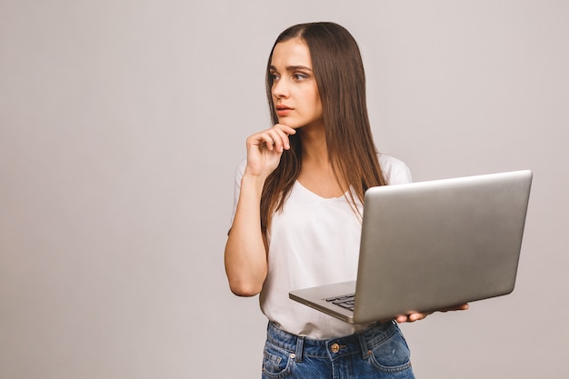 Giovane donna in abiti casual azienda laptop