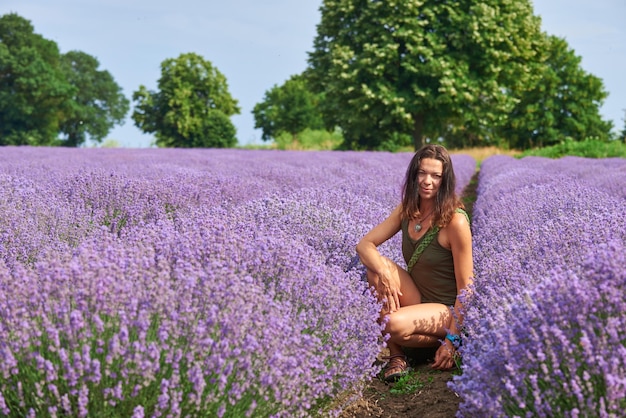 Giovane donna in abiti casual cammina attraverso un campo di lavanda in fiore