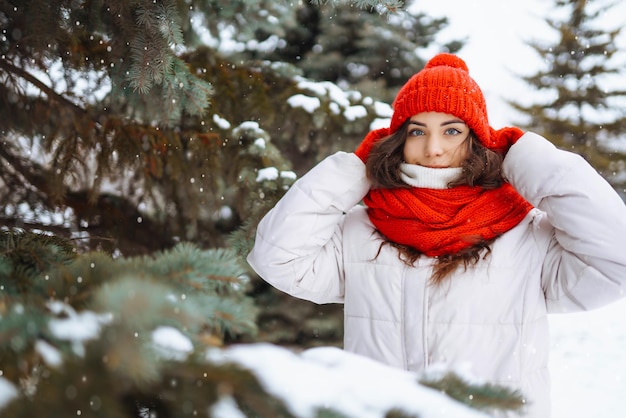 Giovane donna in abiti in stile invernale sullo sfondo della foresta innevata Vacanze nella natura