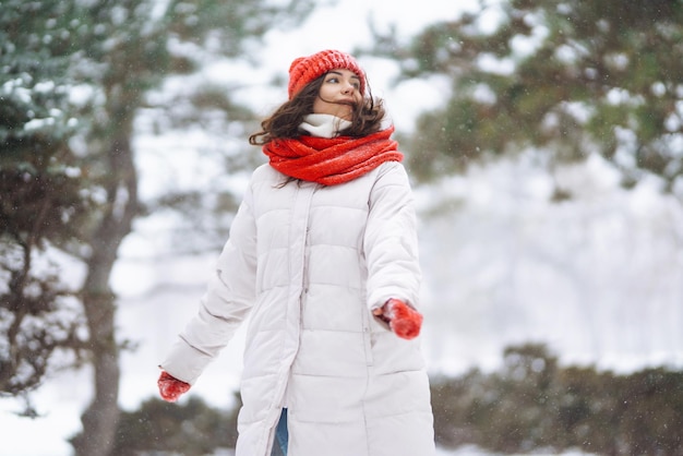 Giovane donna in abiti in stile invernale sullo sfondo della foresta innevata Vacanze nella natura