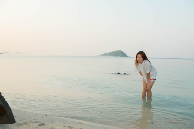 Giovane donna in abito casual e stare in piedi sulla spiaggia