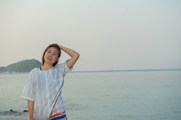 Giovane donna in abito casual e stare in piedi sulla spiaggia