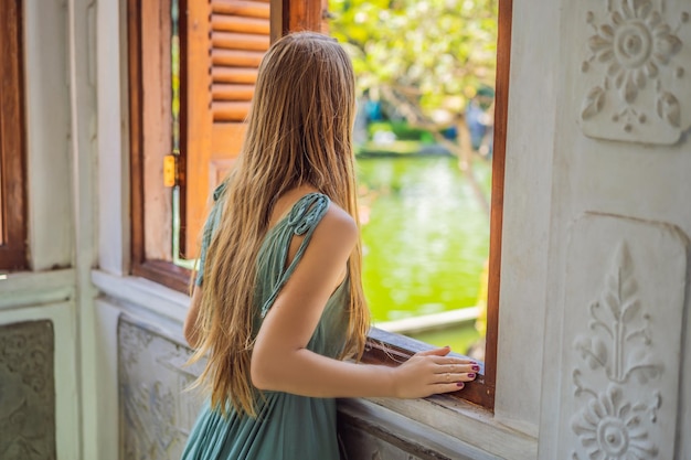 Giovane donna in abito in Water Palace Soekasada Taman Ujung Rovine sull'isola di Bali in Indonesia Incredibile architettura antica Viaggi e vacanze sullo sfondo