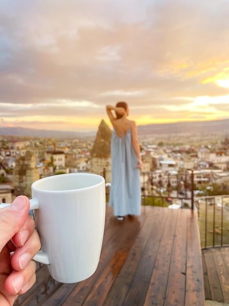 Giovane donna in abito sul tetto con splendida vista della Cappadocia in Turchia