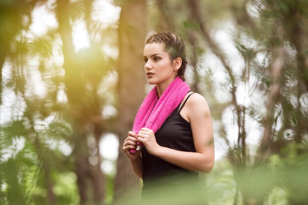 Giovane donna in appoggio dopo l'esecuzione nella foresta boscosa Area formazione ed esercizio per Trail Run Marathon Endurance Fitness uno stile di vita sano Concept